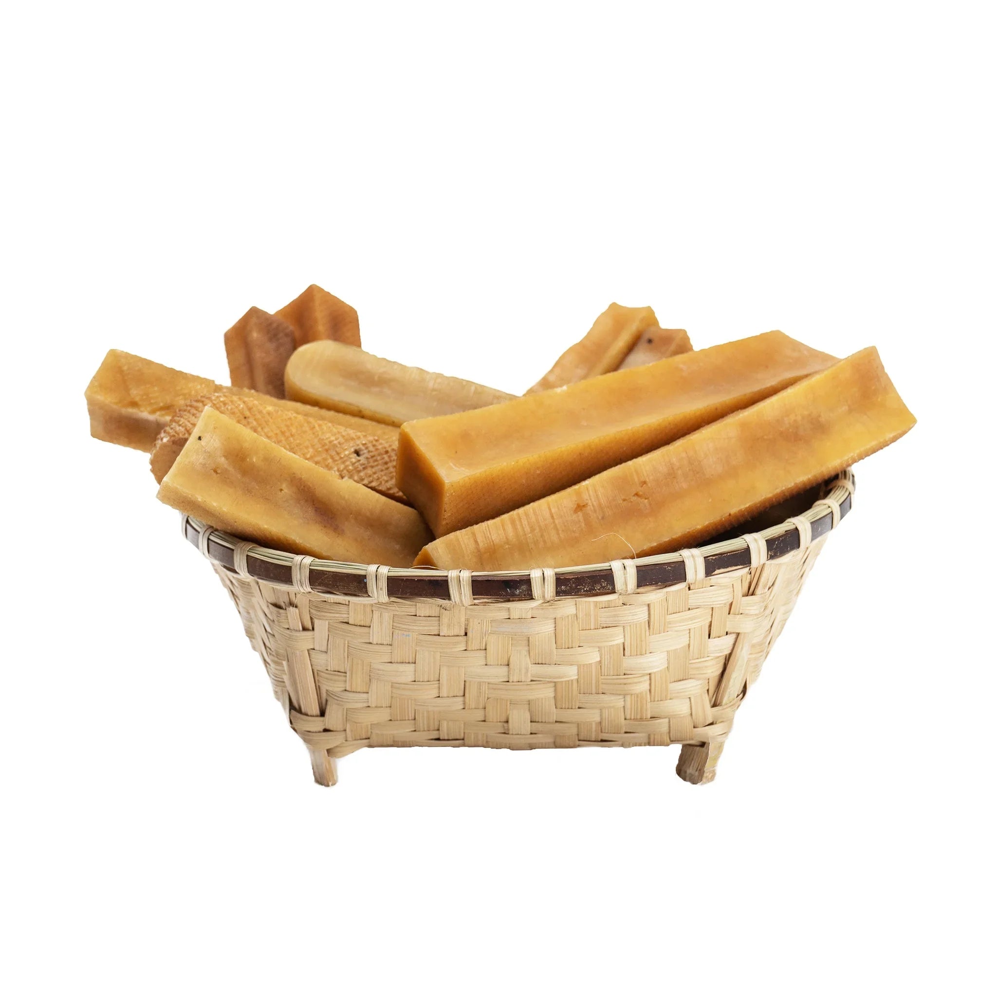 Woven bamboo basket filled with assorted natural beeswax blocks on white background
