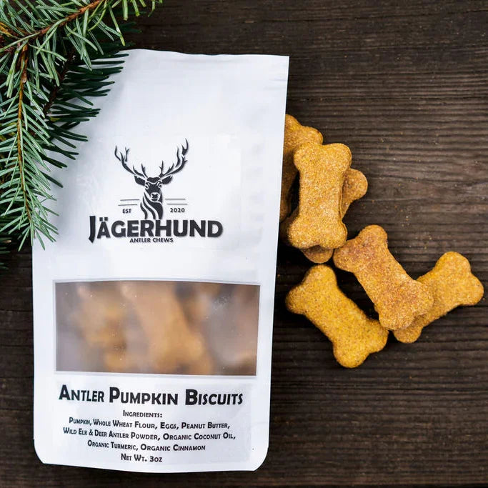 Jägerhund Antler Pumpkin Biscuits dog treats in bone shapes with pine sprig on wooden background