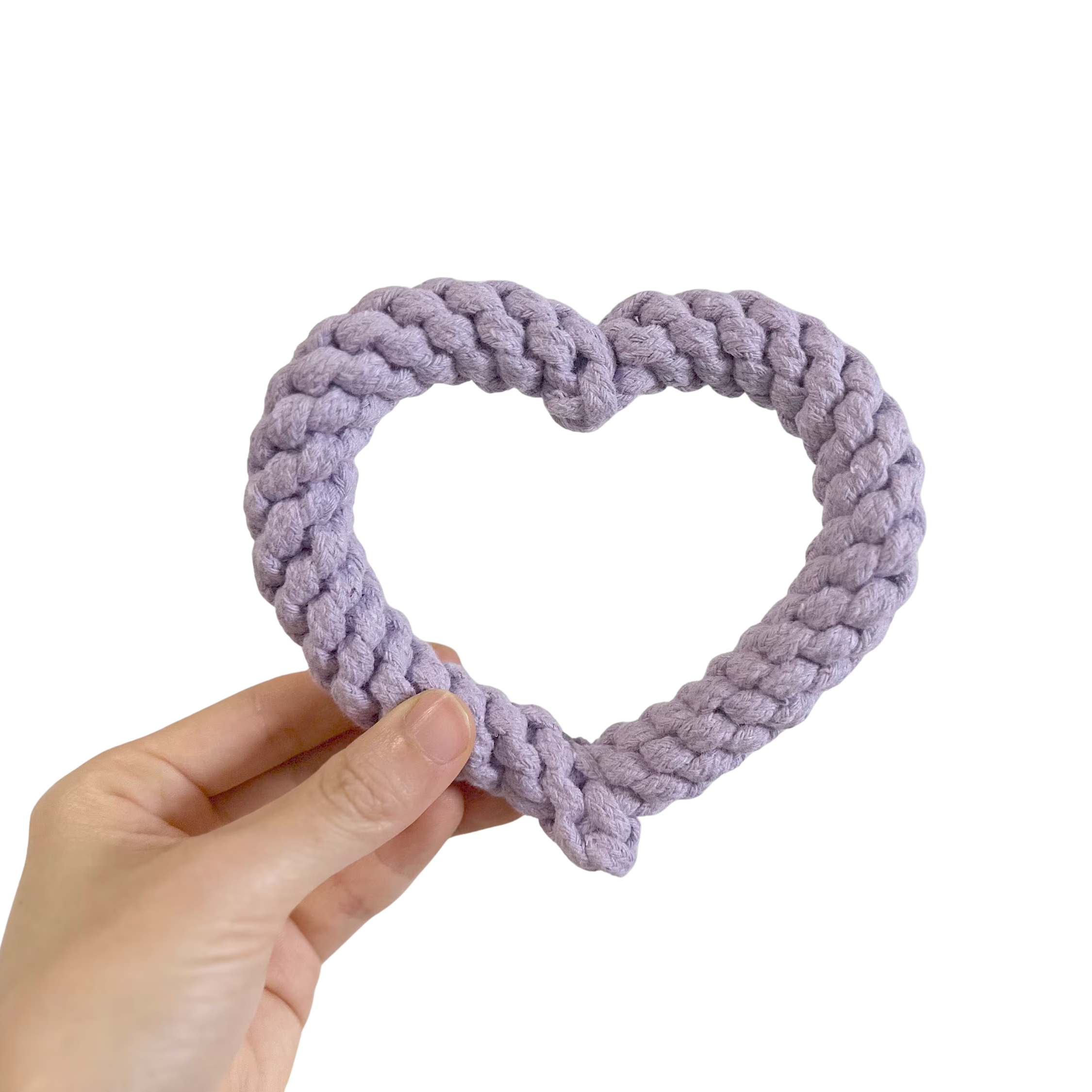 Hand holding a LAVENDER HEART SHAPE DOG TOY against a white background