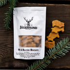 Jägerhund PB & Bacon Biscuits dog treats packaging with deer-shaped biscuits on wooden surface with pine branches