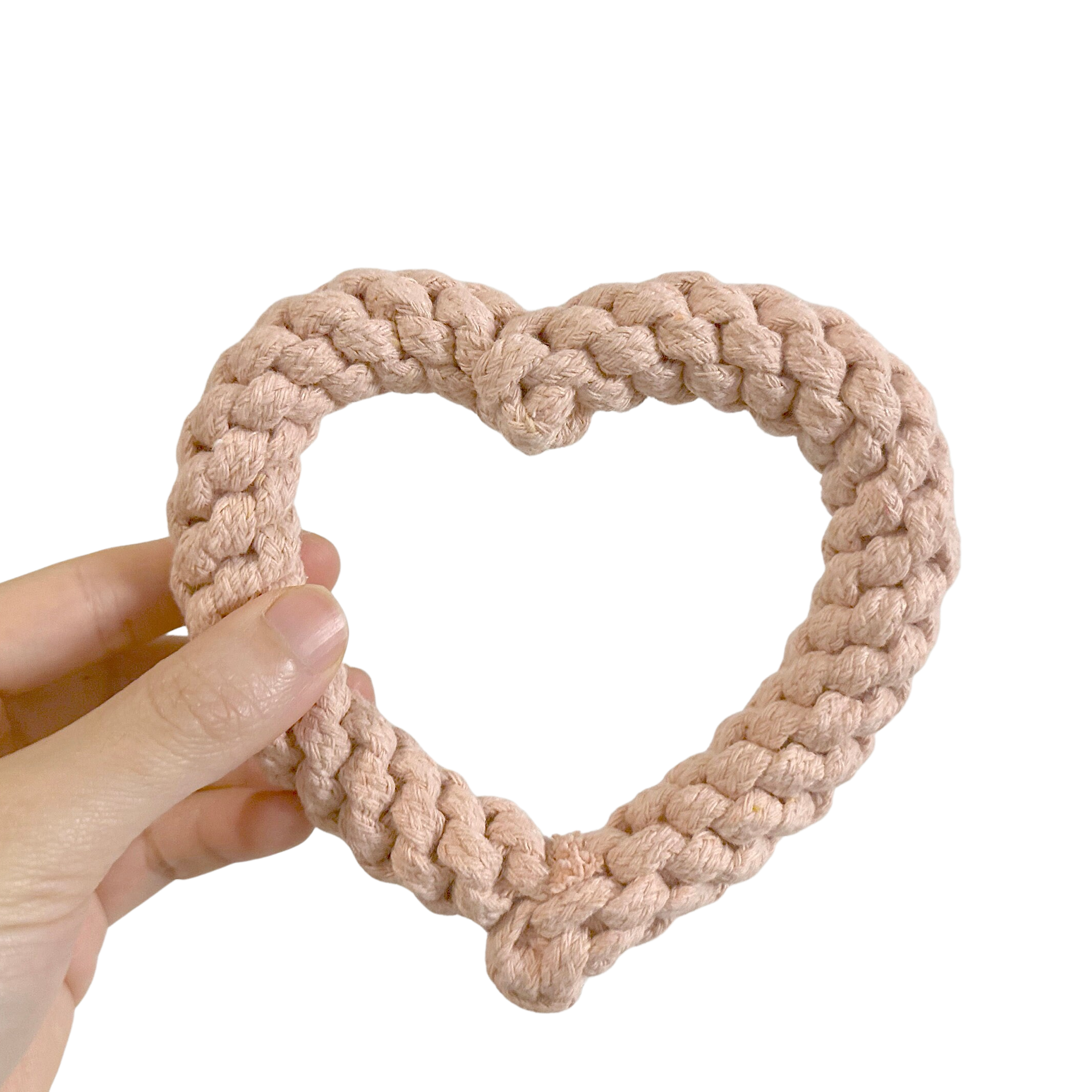 Hand holding a PLUSH PINK HEART SHAPE DOG TOY against a white background