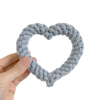 Hand holding a SKY BLUE HEART SHAPE DOG TOY against a white background