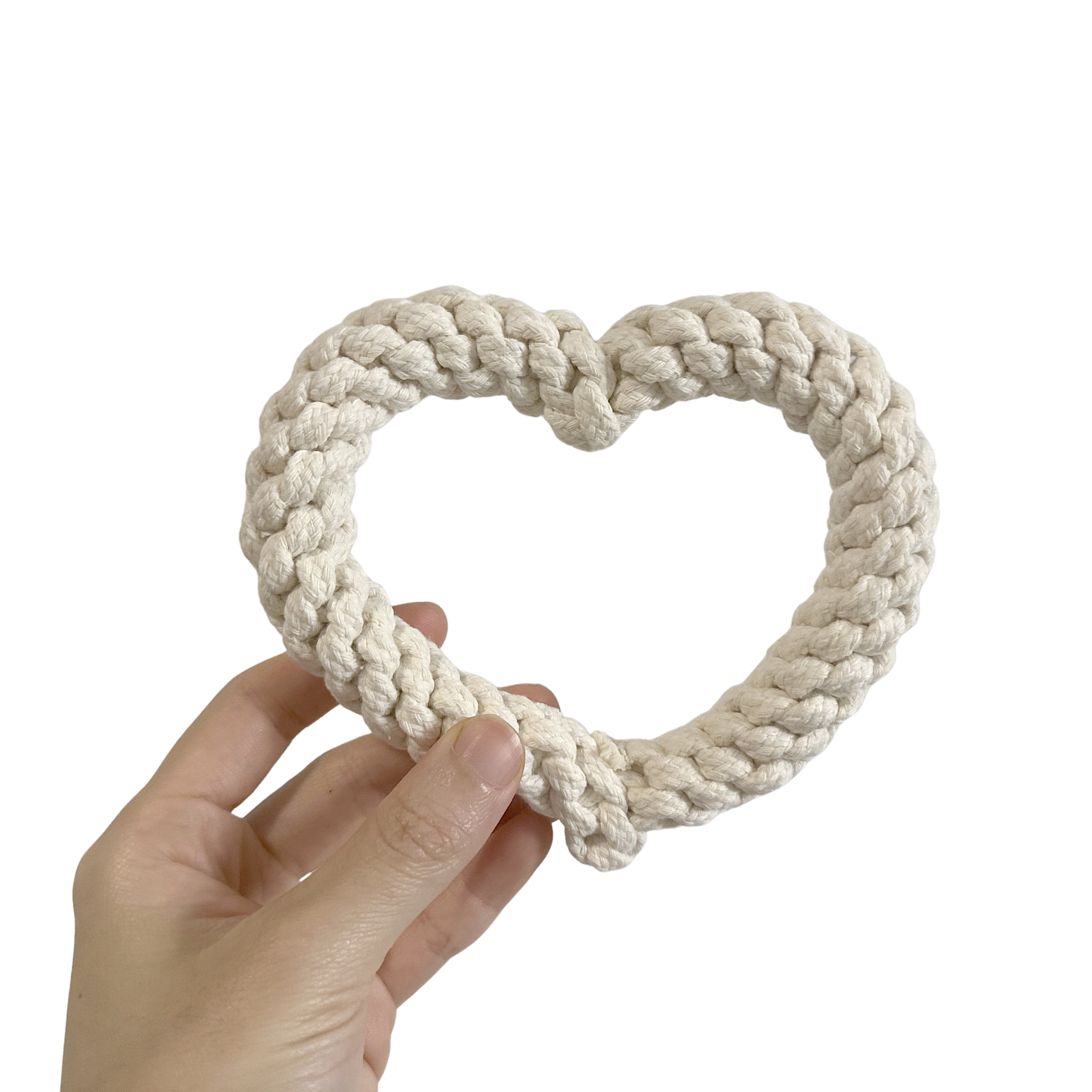Hand holding a WHITE HEART SHAPE DOG TOY against a white background