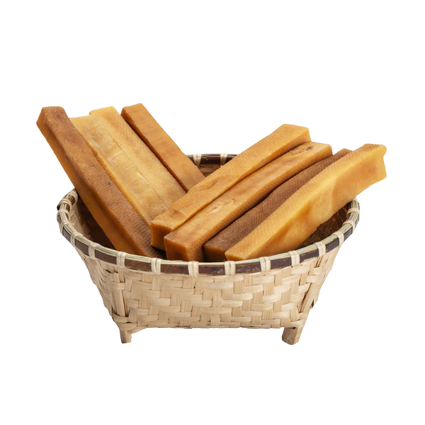 Basket filled with dog churpi cheese chews on a white background